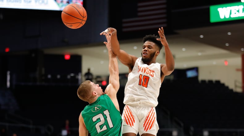 Stivers’ DaJuan Allen passes the ball over Anna’s Riley Huelskamp during their Division III regional semifinal on Wednesday night at UD Arena. The Tigers won 71-63. CONTRIBUTED PHOTO BY MICHAEL COOPER