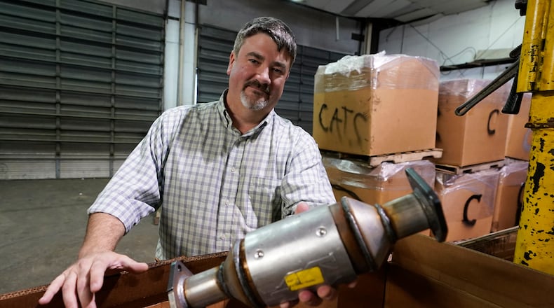 Troy Webber, owner of Chesterfield Auto Parts, holds a used catalytic converter that was removed from one of the cars at his salvage yard Friday Dec. 17, 2021, in Richmond, Va. Thefts of the emission control devices have jumped over the last two years as prices for the precious metals they contain have skyrocketed. (AP Photo/Steve Helber)
