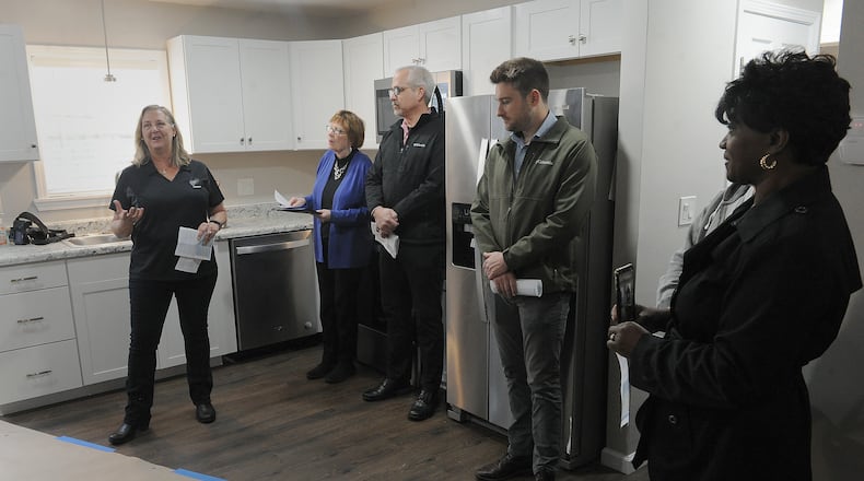 Laura Mercer, left, explains the Tornado Survivor Pathway to Homeownership program, at the open house of a renovated home on Marlin Avenue in Trotwood on Wednesday, April 13, 2022. MARSHALL GORBY\STAFF