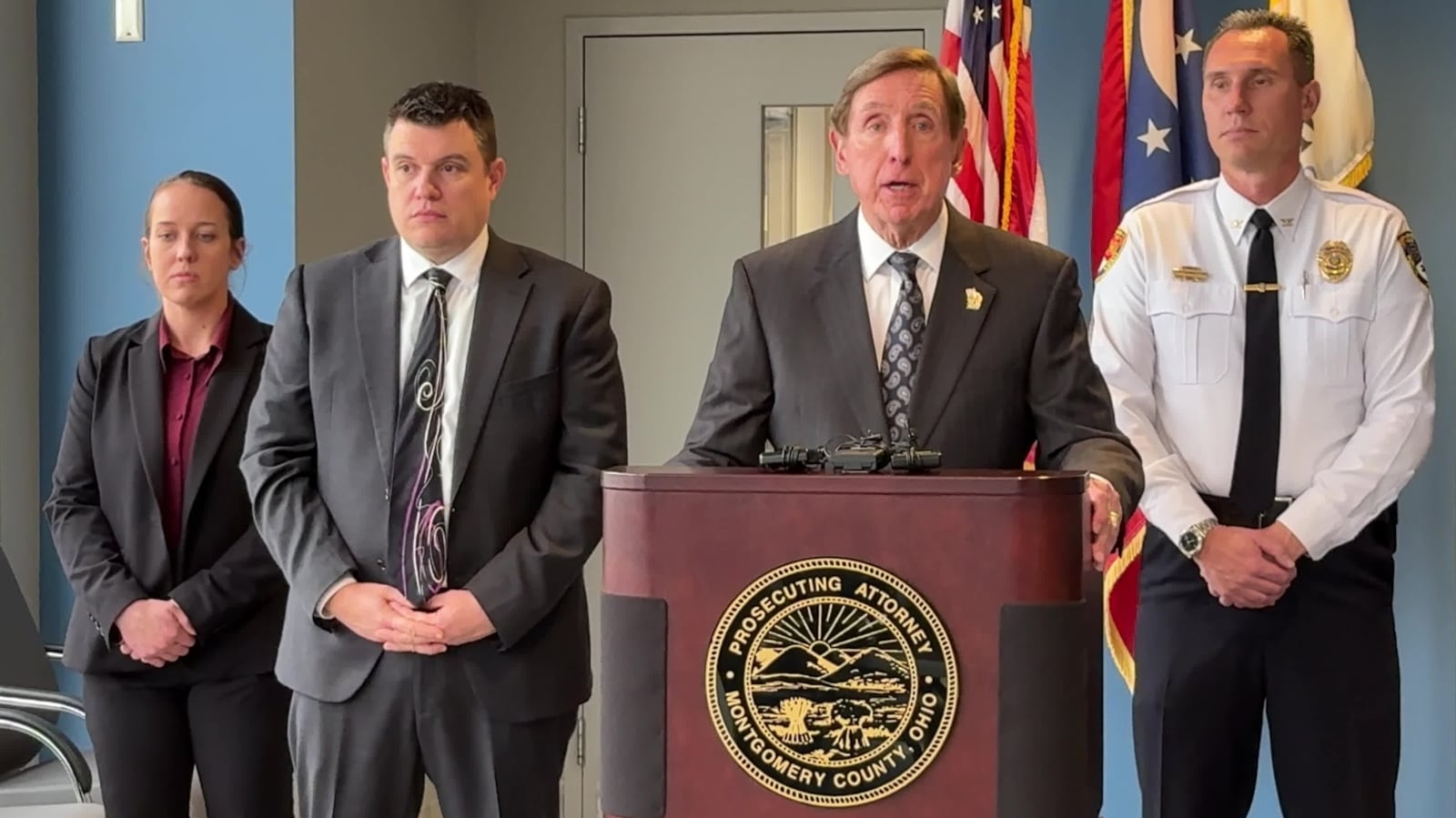 Montgomery County Prosecutor Mat Heck Jr., at podium, announces a 91-count indictment against Oakwood attorney Matthew Currie, who is accused of stalking and secretly recording a teen girl and other women in the neighborhood. At left is Oakwood detective Kasey Ballinger, Bryan Moore, chief of the juvenile division of the prosecutor's office and Alan Hill, chief of the Oakwood Public Safety Department. JEN BALDUF/STAFF