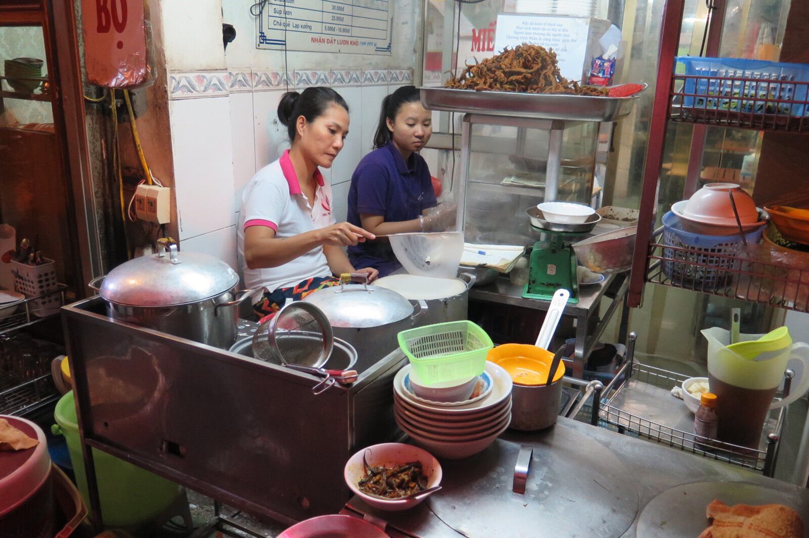 A woman uses a bamboo stick to make steamed rice pancakes. (Alison Bowen/Chicago Tribune/TNS)