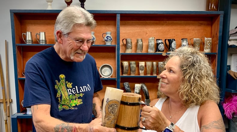 From left: Joey and Kathleen Hall toast the opening of their store in Xenia titled the White Seahorse, dedicated to historical reproductions, costumes, crafting materials and toys. LONDON BISHOP/STAFF