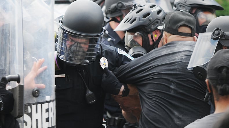 Police take down a protester on Wayne Ave. Saturday. MARSHALL GORBY\STAFF
