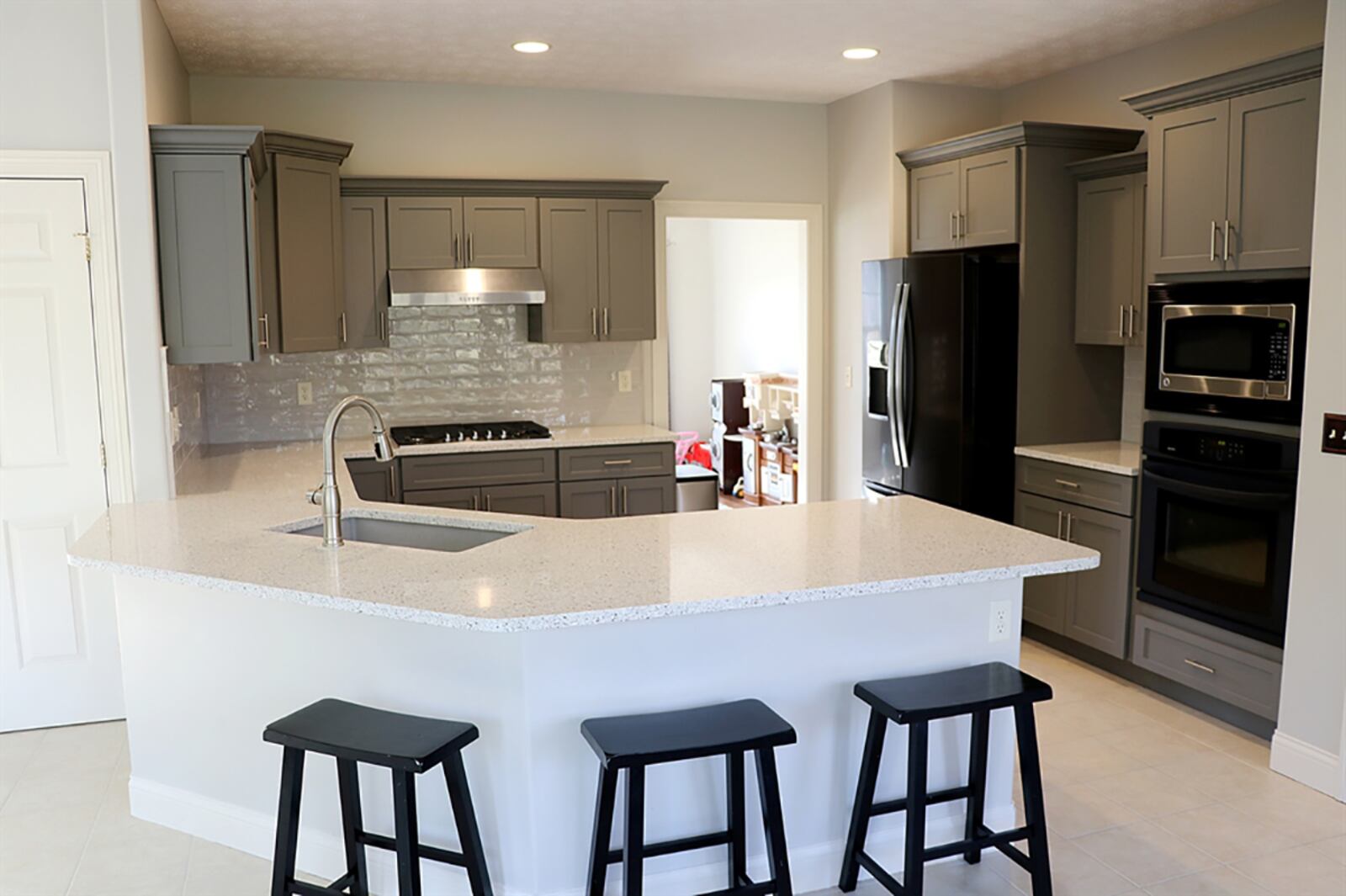 A peninsula counter wraps around the kitchen, creating a step-saving work space and breakfast bar seating for up to six. A stainless-steel sink is nestled within the countertop. CONTRIBUTED PHOTO BY KATHY TYLER