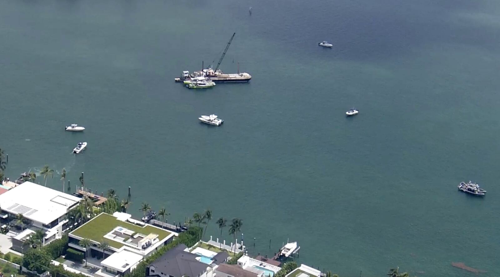 This image taken from video provided by WSVN-TV shows Miami-Dade Fire Rescue and others in boats around what appears to be a barge involved in an accident with a group of kids and an adult on a sailing boat during a sailing camp, Monday, July 28, 2025, in Miami. (WSVN-TV via AP)