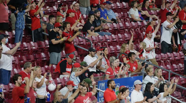 Reds fans cheer after the final out of a victory against the Brewers on Friday, May 21, 2021, at Great American Ball Park in Cincinnati. David Jablonski/Staff