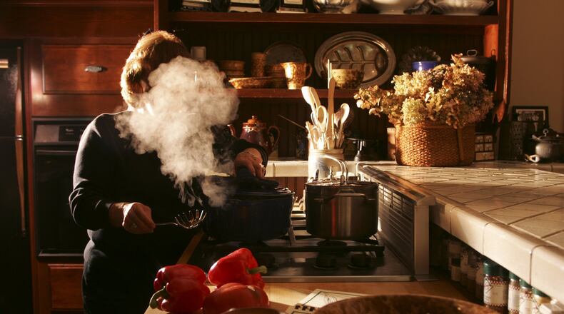 Use the palm of your hand against a chef’s knife to loosen the husk of the garlic clove. STAFF PHOTO / JIM WITMER