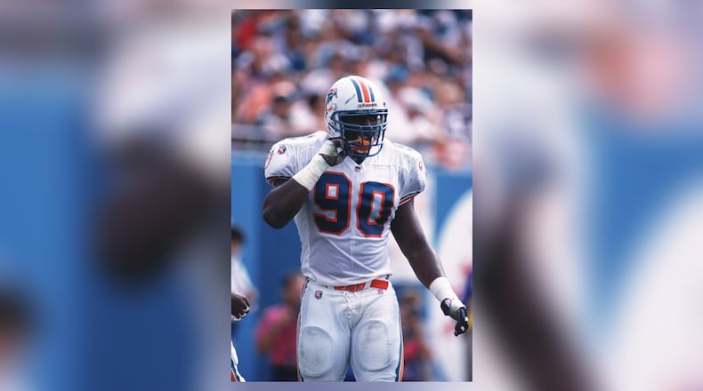 12 Nov 1995: Defensive end Marco Coleman of the Miami Dolphins adjusts his chin strap during the Dolphins 34-17 loss to the New England Patriots at Joe Robbie Stadium in Miami, Florida.