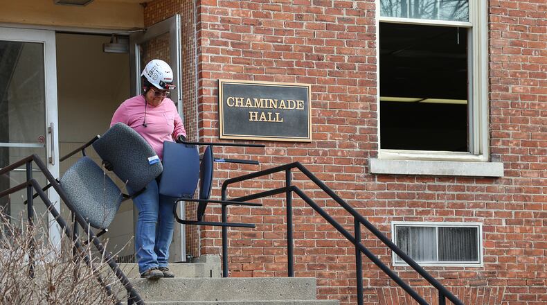 A construction worker takes chairs out of Chaminade Hall on University of Dayton's campus on Wednesday. Crews are clearing out the building ahead of demolition, which is expected to take place later this spring. BRYANT BILLING / STAFF