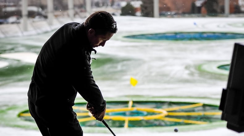 David Allen, Director of Instruction at TopGolf West Chester, hits a ball as the snow falls Thursday, Jan. 5. NICK GRAHAM/STAFF