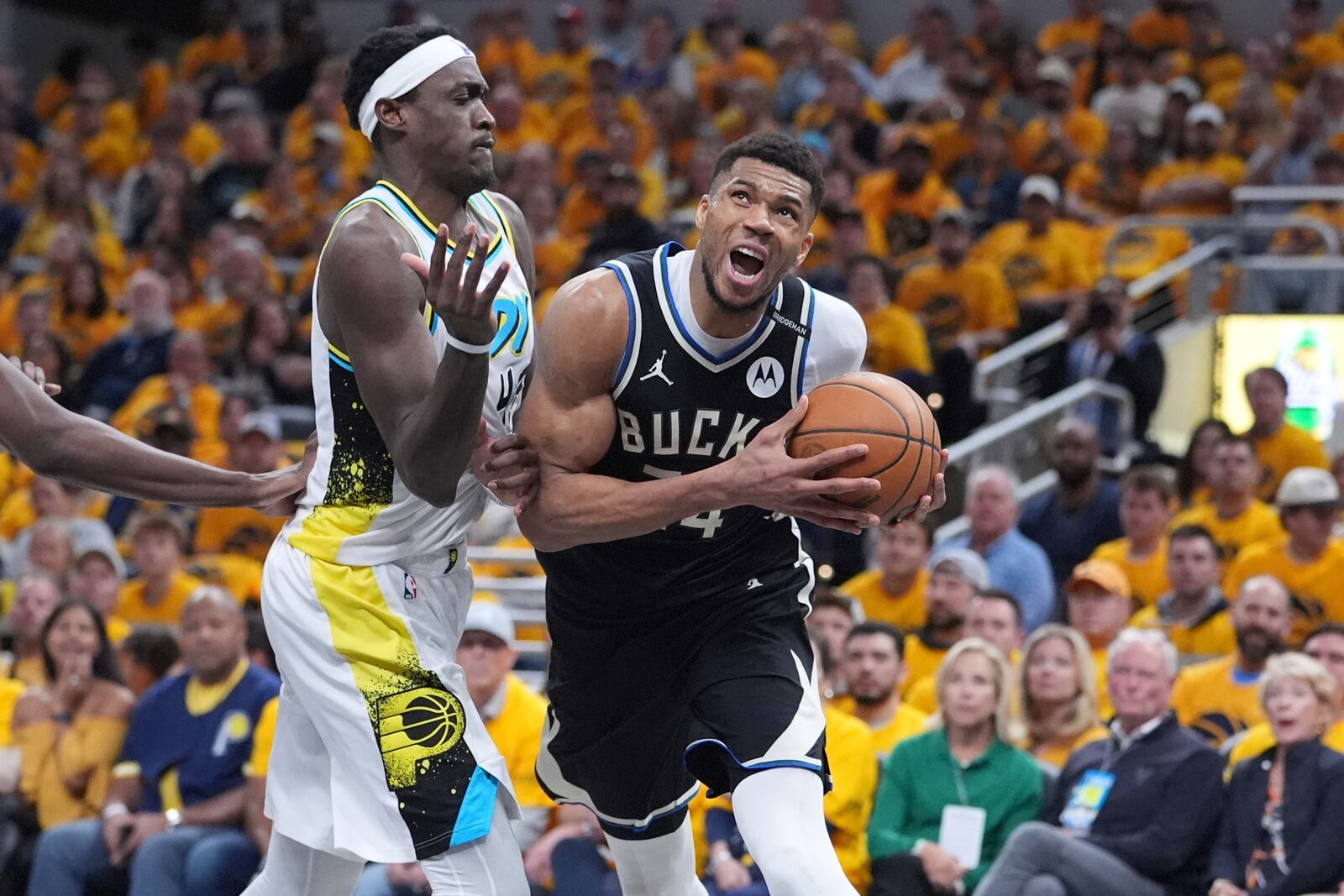 Milwaukee Bucks' Giannis Antetokounmpo, right, heads to the basket as Indiana Pacers' Pascal Siakam defends during the second half of a first-round NBA basketball playoff game, Saturday, April 19, 2025, in Indianapolis. (AP Photo/Michael Conroy)