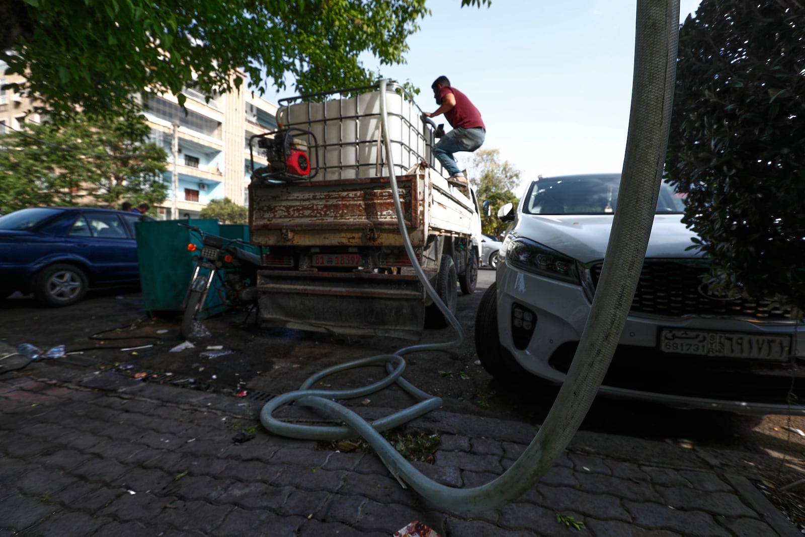 A worker supplies water from a tank to houses in Damascus, Sunday, May 11, 2025.(AP Photo/Omar Sanadiki)