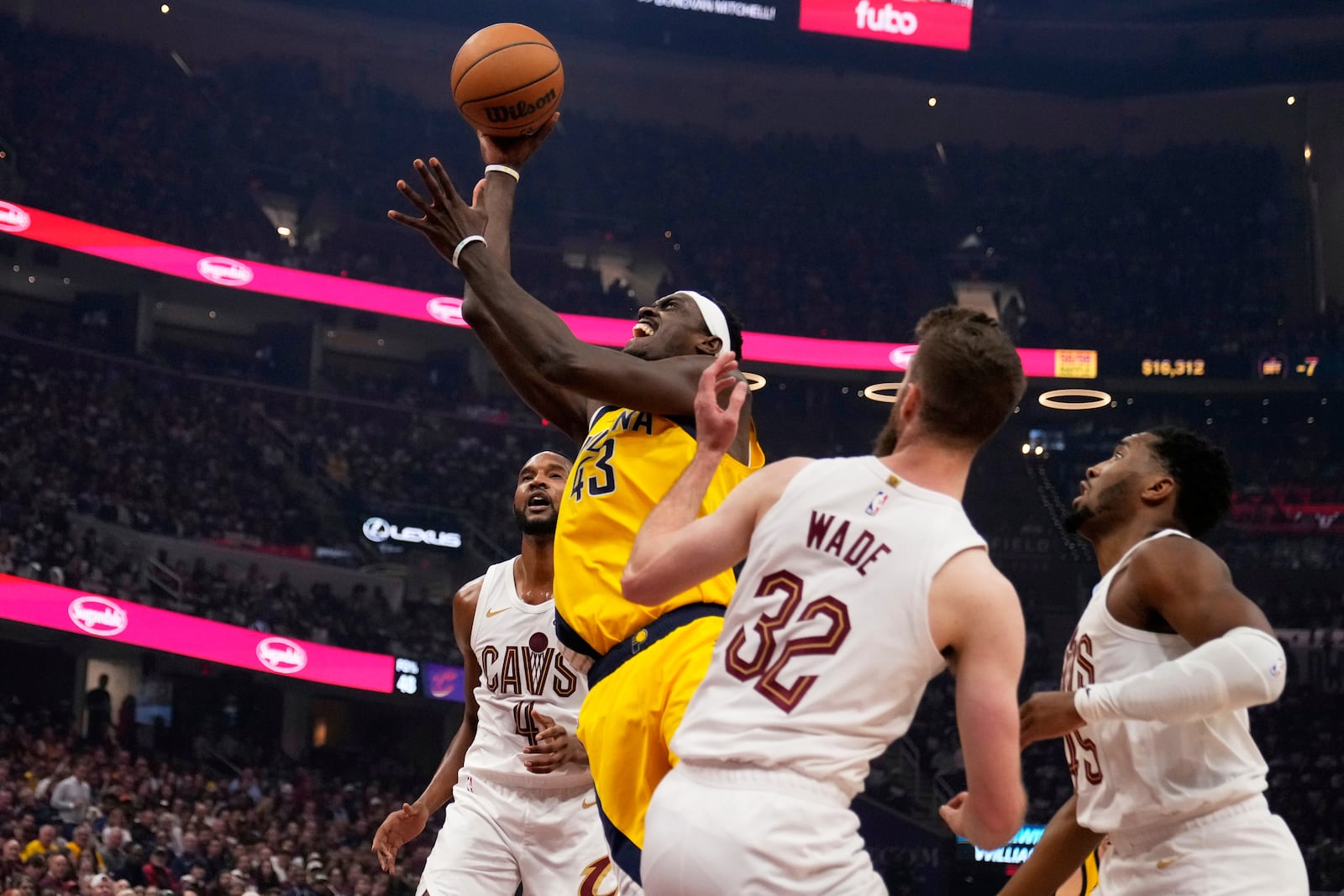 Indiana Pacers forward Pascal Siakam (43) goes to the basket between Cleveland Cavaliers forward Evan Mobley, left, forward Dean Wade (32) and guard Donovan Mitchell, right, in the first half during Game 1 in the Eastern Conference semifinals of the NBA basketball playoffs Sunday, May 4, 2025, in Cleveland. (AP Photo/Sue Ogrocki)