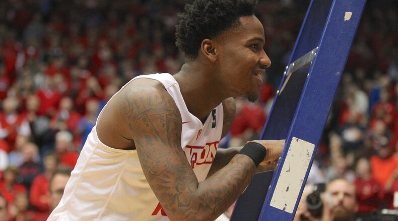 Dayton’s John Crosby smiles after cutting down the net after a victory against Virginia Commonwealth on Wednesday, March 1, 2017, at UD Arena. David Jablonski/Staff