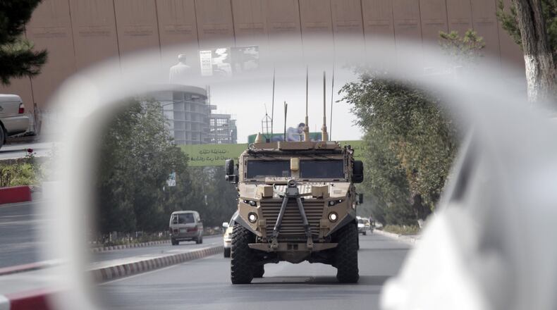 A patrolling U.S. armored vehicle is reflected in the mirror of a car in Kabul, Afghanistan, Wednesday, Aug. 23, 2017. In a national address Monday night, U.S. President Donald Trump reversed his past calls for a speedy exit and recommitted the United States to the 16-year-old conflict, saying U.S. troops must “fight to win.” (AP Photo/Rahmat Gul)
