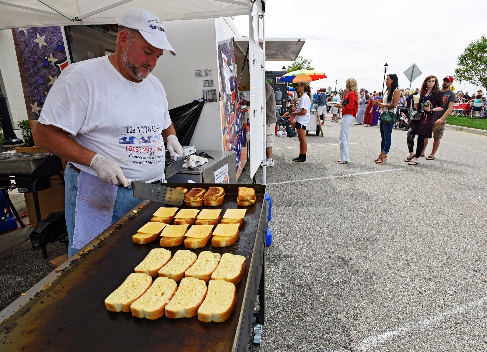 Greg Carter with 1776 Grill from Lebanon makes grilled cheese sandwiches on garlic bread during West Chester's annual Union Centre Food Truck Rally held Friday, August 14 at The Square @ Union Centre. NICK GRAHAM/STAFF