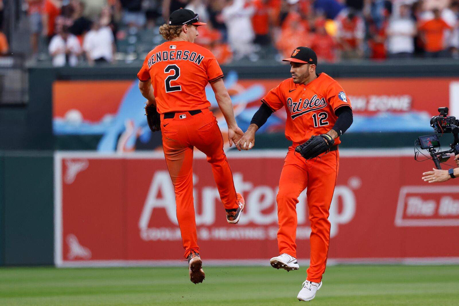 Baltimore Orioles shortstop Gunnar Henderson, left, leaps to high five Ramon Laureano, right, after the final out in the ninth inning of a baseball game against the Cincinnati Reds, Saturday, April 19, 2025, in Baltimore. (AP Photo/Alyssa Howell)