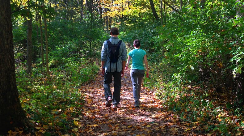 Amid peak fall color, hikers walk the Pittsburgh-Cincinnati Stagecoach Trail in John Bryan State Park that follows the course of the Little Miami River and is wide enough for two people. John Bryan near Yellow Springs is considered by many to be the most scenic state park in western Ohio. CONTRIBUTED