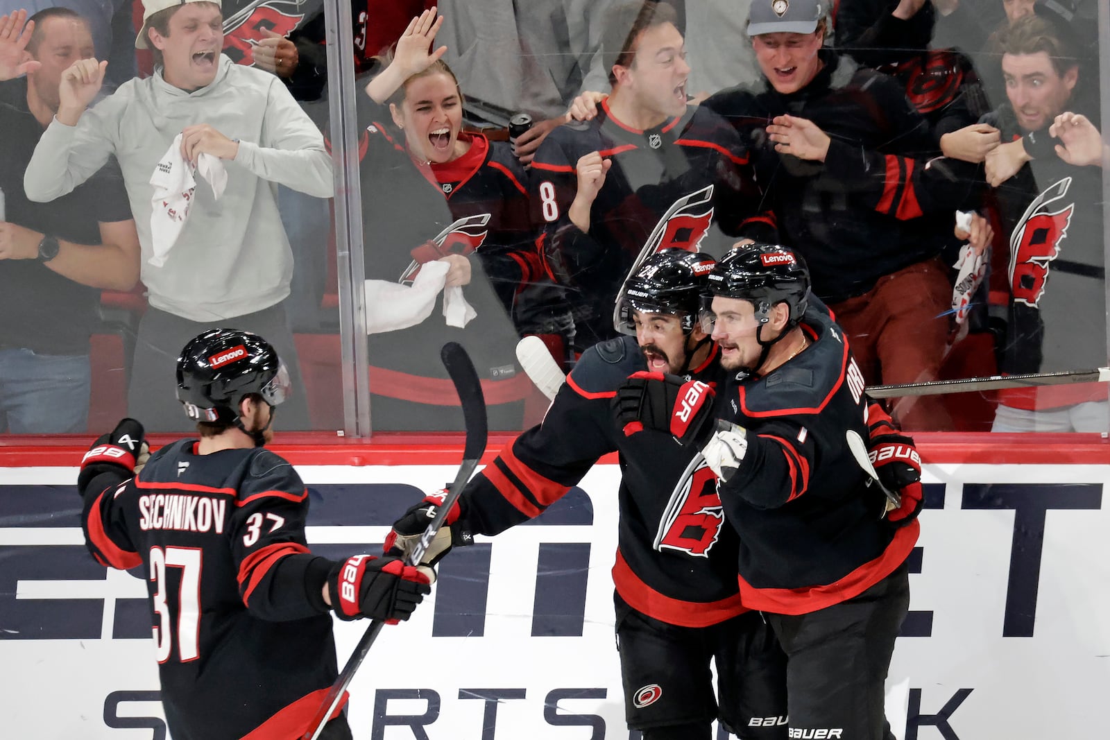 Carolina Hurricanes center Seth Jarvis, center, celebrates his goal with right wing Andrei Svechnikov (37) and defenseman Dmitry Orlov, right, after he scored against the Florida Panthers during the third period of Game 5 of the NHL hockey Stanley Cup Eastern Conference finals Wednesday, May 28, 2025, in Raleigh, N.C. (AP Photo/Chris Seward)