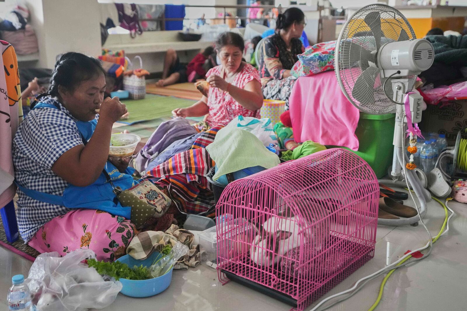 Bualee Chanduang, left, with her rabbit who fled homes following clashes between Thai and Cambodian soldiers at an evacuation center in Surin province,Thailand, Sunday, July 27, 2025. (AP Photo/Sakchai Lalit)