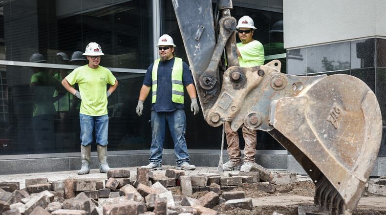 Workers replace the brick sidewalks around the Dayton Convention Center on 5th Street with concrete walkways Monday May 6, 2024. JIM NOELKER/STAFF