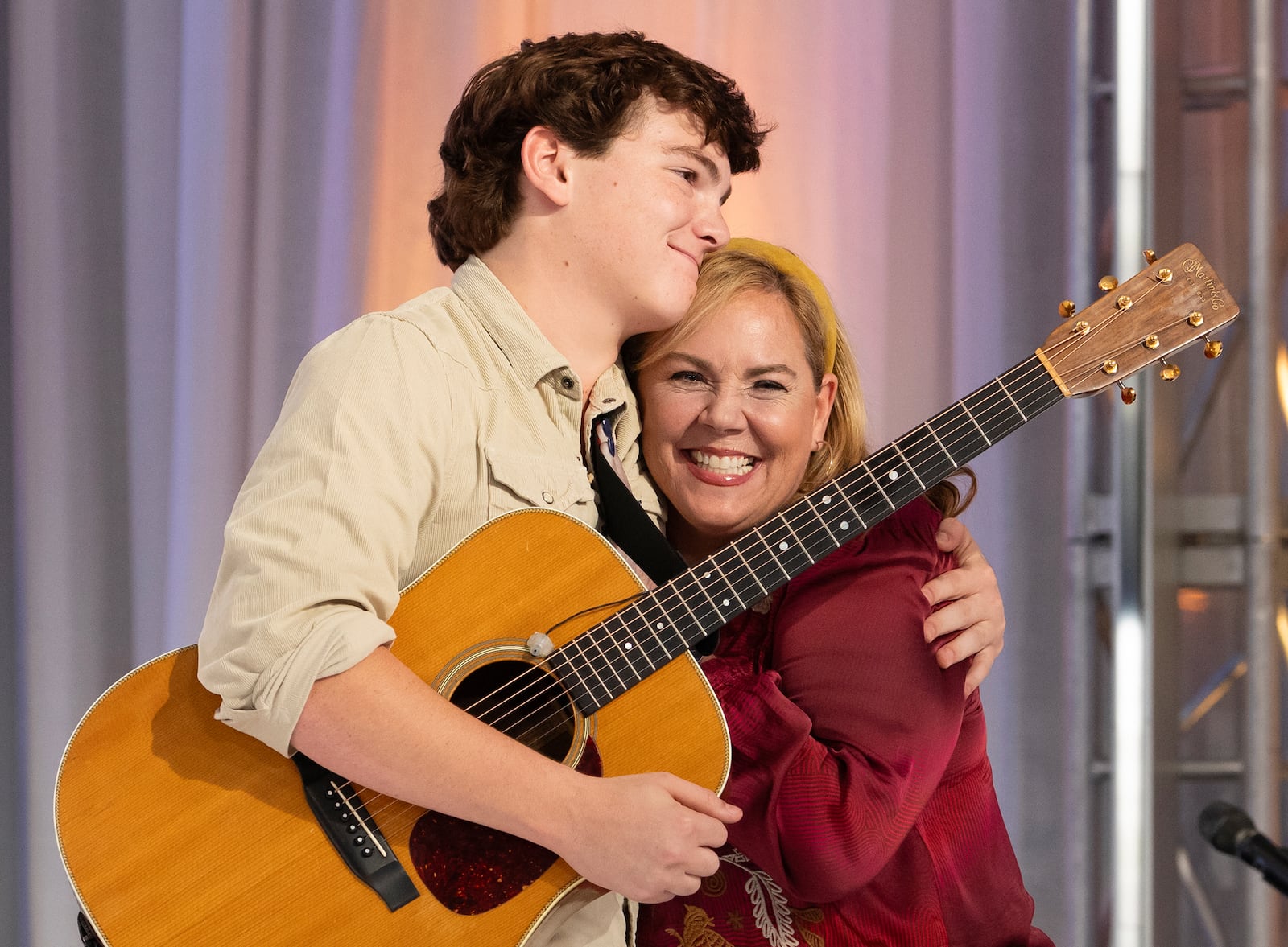 This image released by Disney shows contestant Slater Nalley, left, embracing his English teacher Mrs. Davis during auditions for the singing competition series "American Idol" in Nashville, Tenn. (Eric McCandless/Disney via AP)