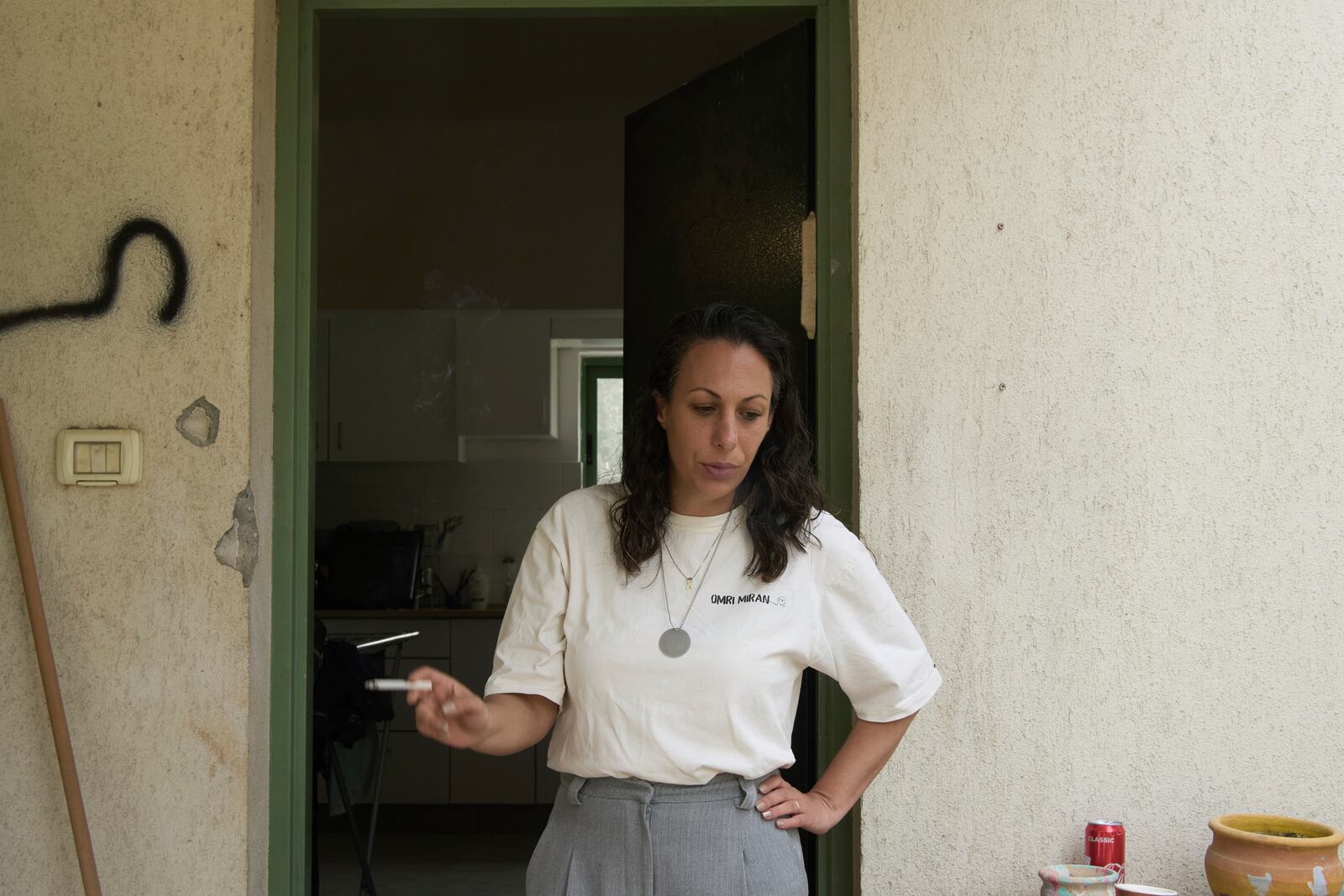 Lishay Miran Lavi, whose husband of Omri Miran is held captive by Hamas in the Gaza Strip, smokes at the family's home in Kibbutz Nahal Oz, southern Israel, Wednesday, April 9, 2025. (AP Photo/Maya Alleruzzo)