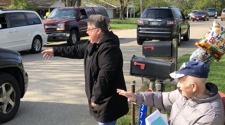 Patty Caudell reaches for another birthday card for her husband, Charles Caudell, who turned 91 Thursday. His family and friends surprised him with a birthday party parade because they couldn’t attend a birthday party because of the coronavirus. RICK McCRABB/STAFF