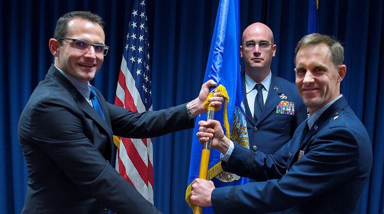 Dr. Will Roper (left), U.S. Air Force assistant secretary for Acquisition, Technology and Logistics, presents Brig. Gen. John P. Newberry with a guidon, May 31 as Newberry assumes leadership of the directorate during a ceremony at Wright-Patterson Air Force Base. Senior Master Sgt. Shawn R. Akers, Tanker Directorate superintendent stands by to take the guidon from Newberry. (U.S. Air Force photo/R.J. Oriez)