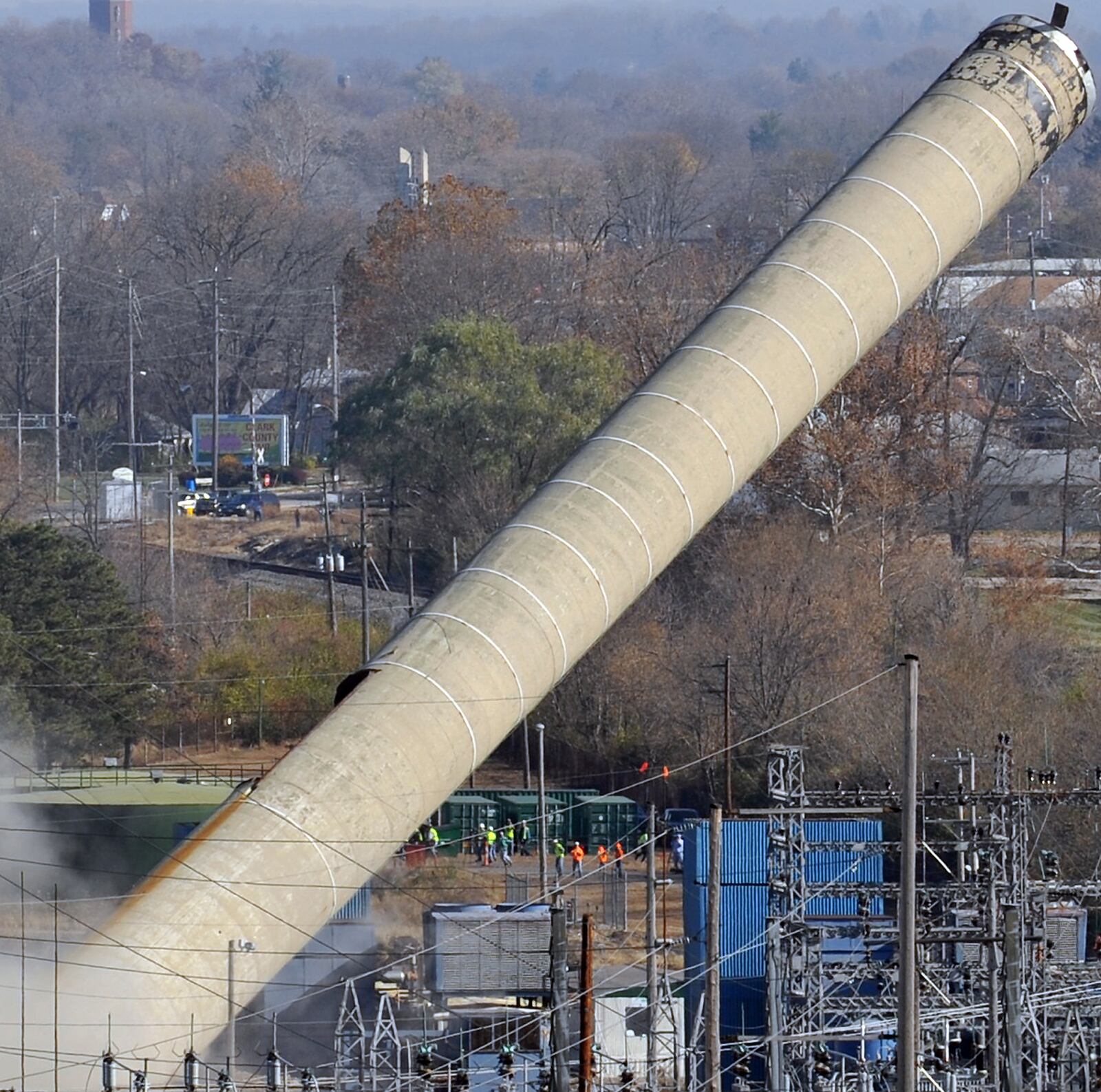 The former Ohio Edison Mad River Power Plant's 275-foot smoke stack falls toward spectators and surrounding buildings as it falls the wrong way during its domolition Wednesday, Nov. 10. Staff photo by Bill Lackey