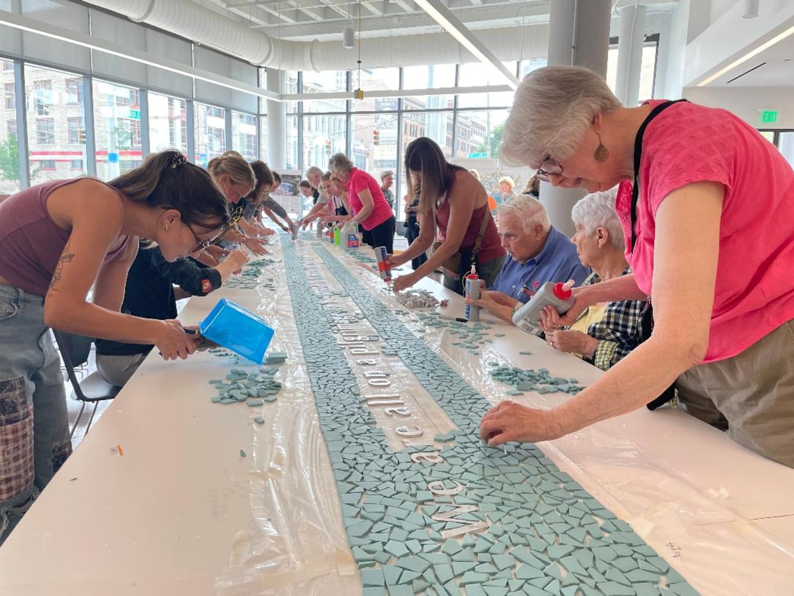 Community volunteers gathered July 11, 2024 at the Dayton Metro Library to finish the creation of the "Seed of Life" 8/4 Memorial mosaic. PHOTO BY RUSSELL FLORENCE JR.