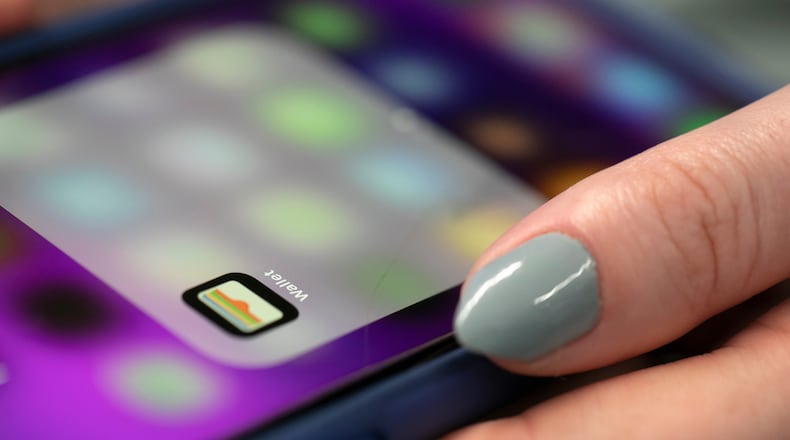 FILE - A person uses an iPhone on Oct. 8, 2019 in New York. ne models and later some Mac computers to get access to genuine Apple parts and tools to be able to repair them. (AP Photo/Jenny Kane, File)