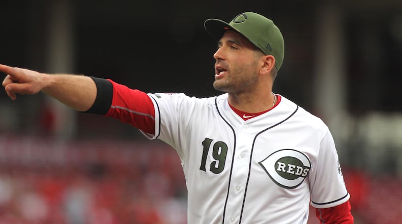 Reds first baseman Joey Votto points to first base coach Delino DeShields after DeShield's son singled in the first for the Rangers on Friday, June 14, 2019, at Great American Ball Park in Cincinnati. Votto said, "You can't cheer!"