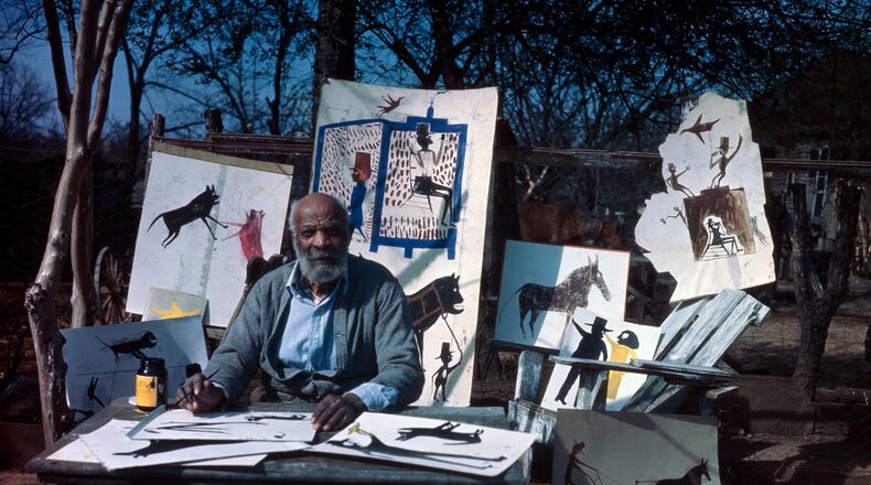 Bill Traylor sits before a display of his artwork. CONTRIBUTED/PHOTO BY HORACE PERRY, COURTESY ALABAMA STATE COUNCIL ON THE ARTS