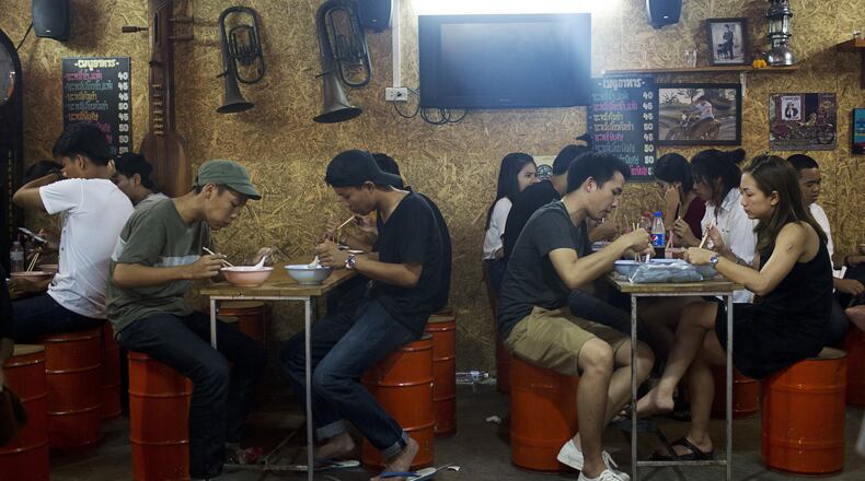 Diners eat at a restaurant at the Jatujak Green night market. (Bloomberg photo by Brent Lewin)