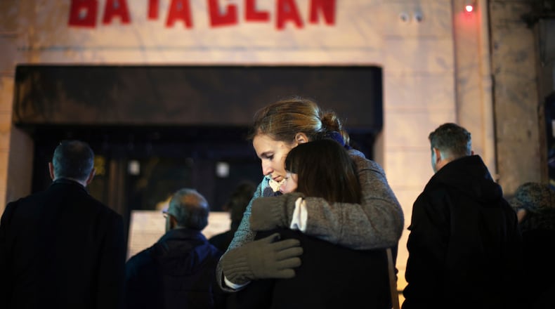 FILE - Women hug in front of the Bataclan concert hall in Paris on Nov. 13, 2016 . (AP Photo/Thibault Camus, File)