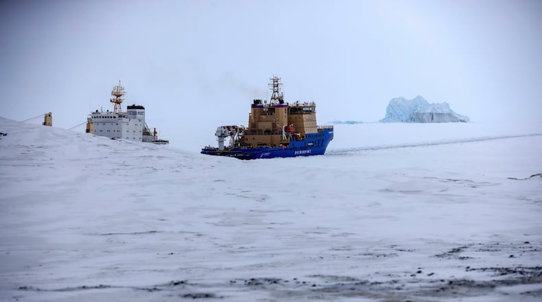 FILE - An Icebreaker makes the path for a cargo ship with an iceberg in the background near a port on the Alexandra Land island near Nagurskoye, Russia, May 17, 2021. (AP Photo/Alexander Zemlianichenko, File)