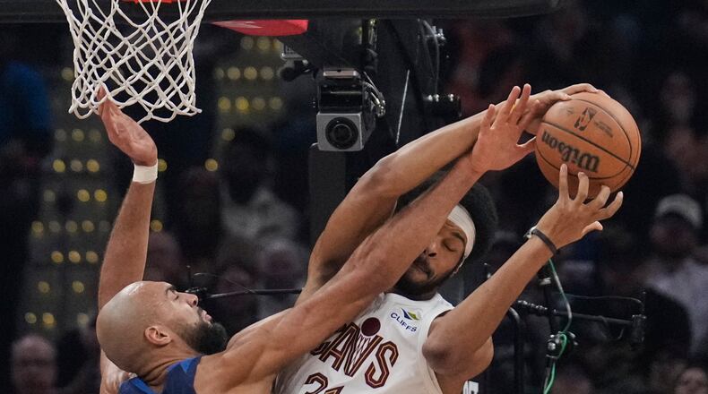 Minnesota Timberwolves center Rudy Gobert, left, fouls Cleveland Cavaliers center Jarrett Allen, right, in the first half of an NBA basketball game Sunday, Jan. 4, 2026, in Cleveland. (AP Photo/Sue Ogrocki)