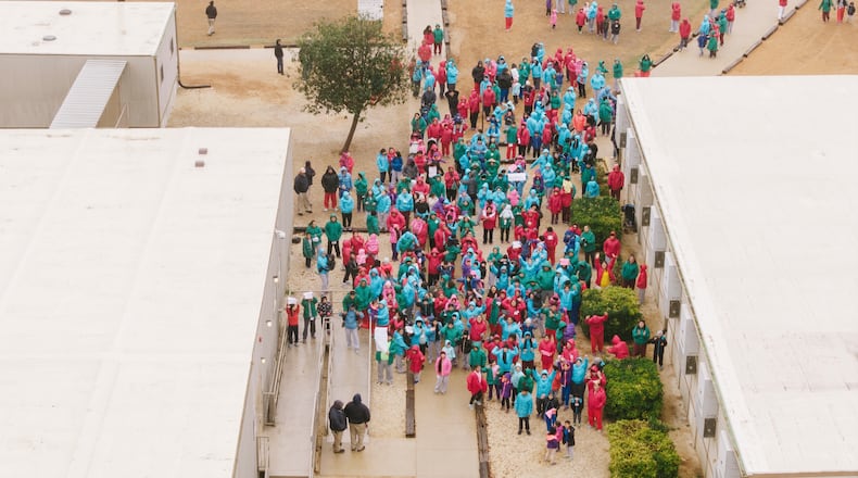 Detainees held at the South Texas Family Residential Center wave signs during a demonstration in Dilley, Texas, Saturday, Jan. 24, 2026. (AP Photo/Brenda Bazán)