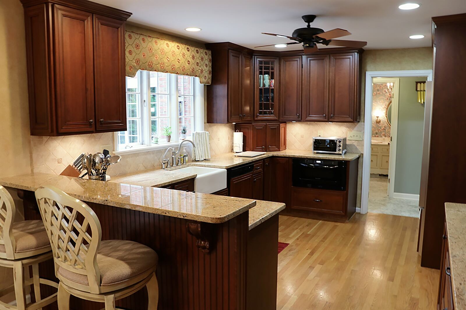 Kitchen and breakfast rooms have an abundance of cabinetry, including a buffet counter with spice drawers and a corner china hutch. A farm sink is below a window, and the appliances have matching cherry wood panels. CONTRIBUTED PHOTO BY KATHY TYLER