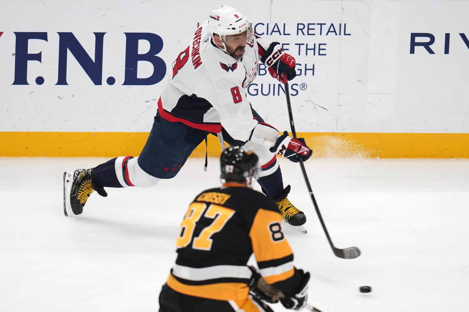 Washington Capitals' Alex Ovechkin (8) shoots with Pittsburgh Penguins' Sidney Crosby (87) defending during the first period of an NHL hockey game in Pittsburgh, Thursday, April 17, 2025. (AP Photo/Gene J. Puskar)