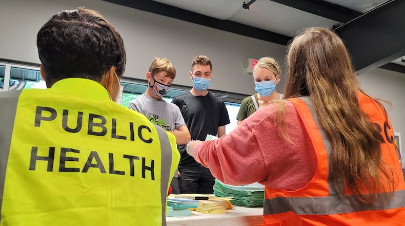 Crystal Dwyer gets her sons, Chase Dwyer, 12, and Brendan Dwyer, 17, registered to receive their COVID-19 vaccines Wednesday, June 9, 2021 at the Butler County Fairgrounds. The Butler County Health Department with help from other agencies continues their COVID-19 vaccination clinics with Walk-in Wednesdays at the Butler County Fairgrounds in Hamilton. The clinic runs from 9 a.m. until noon on Wednesdays. NICK GRAHAM / STAFF