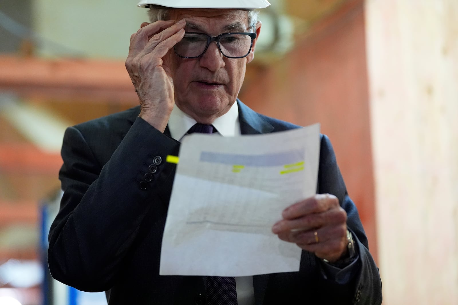 Federal Reserve Chairman Jerome Powell looks over a document of cost figures as President Donald Trump visits the Federal Reserve, Thursday, July 24, 2025, in Washington. (AP Photo/Julia Demaree Nikhinson)