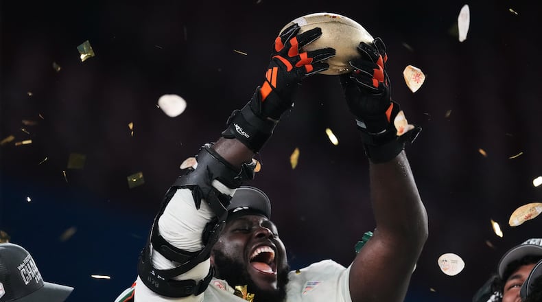 Miami offensive lineman Markel Bell holds up a trophy after winning the Fiesta Bowl NCAA college football playoff semifinal game against Mississippi, Thursday, Jan. 8, 2026, in Glendale, Ariz. (AP Photo/Ross D. Franklin)