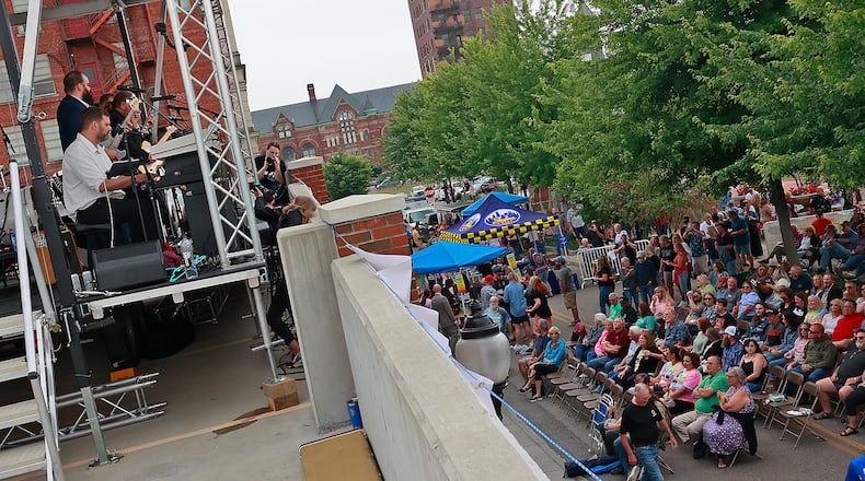 Hundreds of people gathered in National Road Commons Park in downtown Springfield for the Come Together Springfield 2023 - A Rooftop Beatles Tribute Friday, June 16, 2023. The Beatles tribute band played from the top of the city parking garage over looking the sea of music lovers that covered the park in their lawn chairs and blankets. The event also featured food trucks and refreshments. BILL LACKEY/STAFF