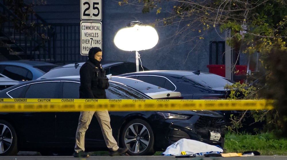 Investigators examine the scene of a mass shooting Sunday, Nov. 30, 2025, in Stockton, Calif. (AP Photo/Ethan Swope)