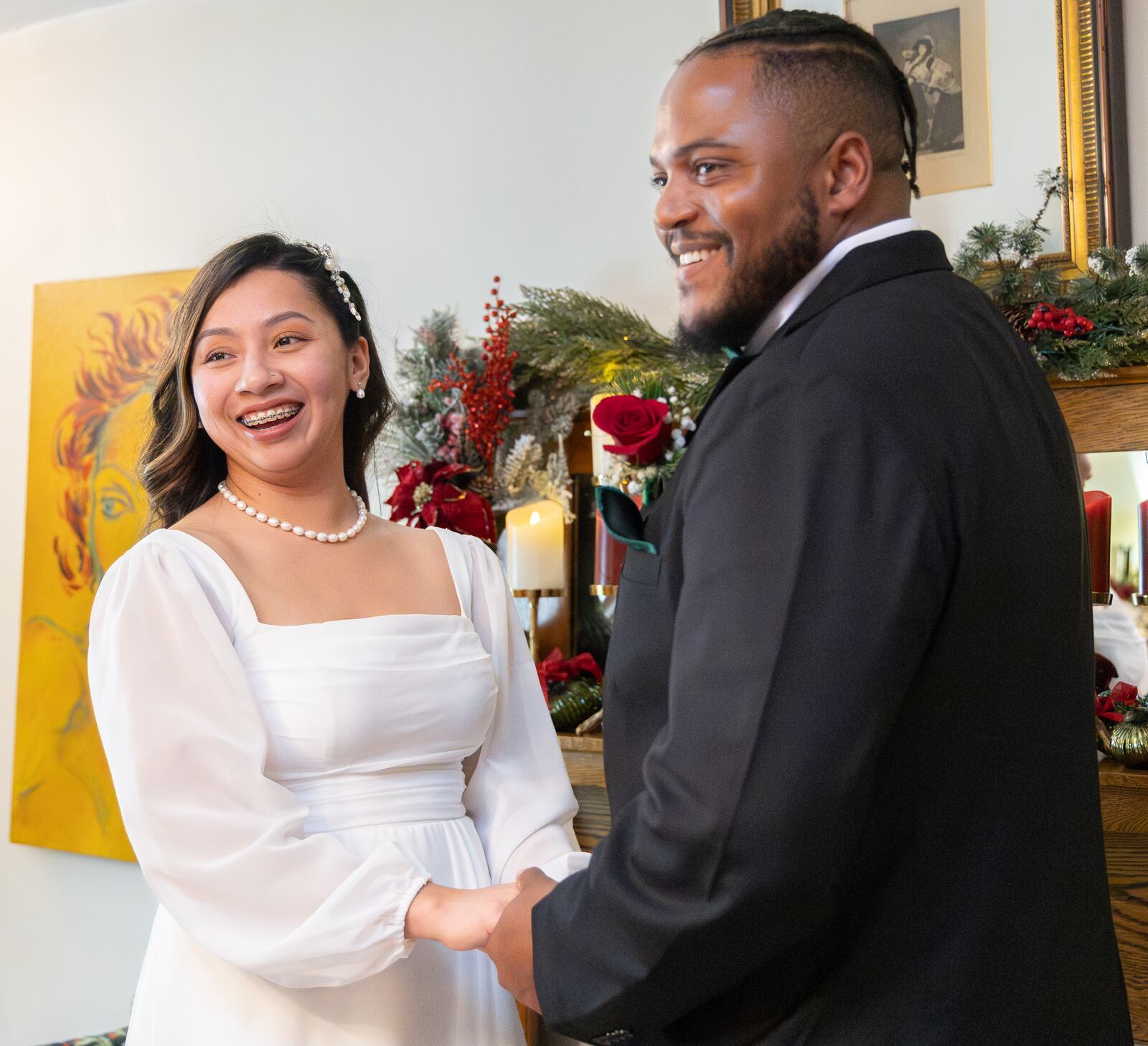 Selena Huerta-Marquez (left) and Xavier Castillo smile during their wedding ceremony in the apartment of Isabel Suarez on Friday, Dec. 26. BRYANT BILLING/STAFF