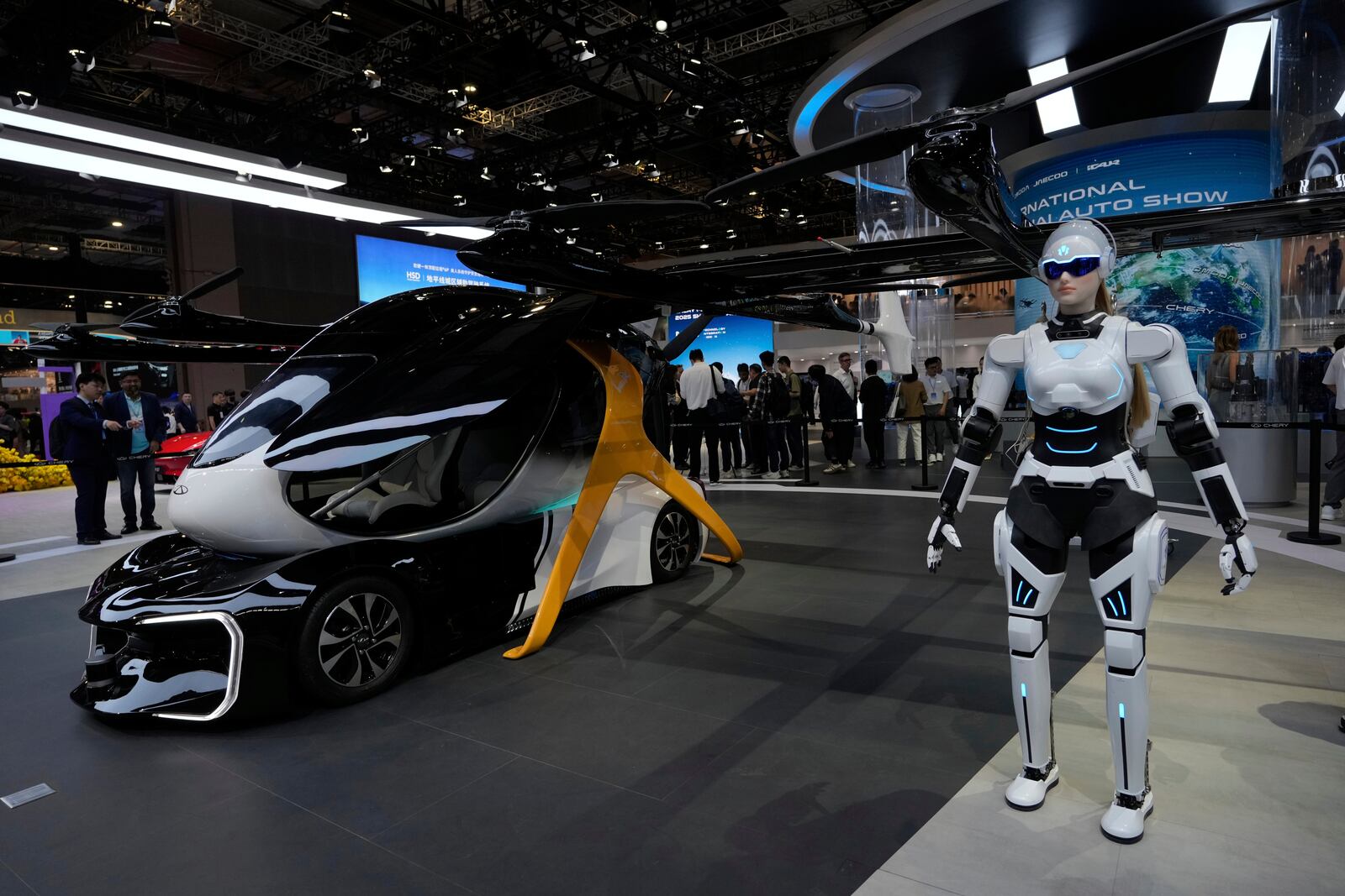 A robot stands next to a concept flying vehicle from Chery at the Shanghai auto show on Wednesday, April 23, 2025. (AP Photo/Ng Han Guan)