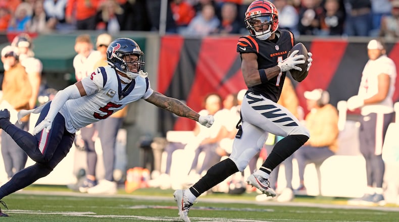 Cincinnati Bengals wide receiver Ja'Marr Chase (1) looks back at Houston Texans safety Jalen Pitre (5) while making a catch and run for a 64-yard touchdown during the second half of an NFL football game Sunday, Nov. 12, 2023, in Cincinnati. (AP Photo/Carolyn Kaster)