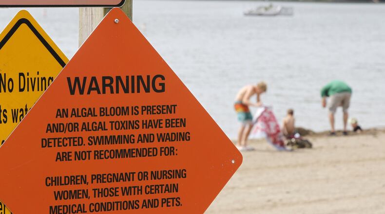 Signs have been posted along the beach at Caesar Creek Lake warning of an algal bloom in the water. TY GREENLEES / STAFF